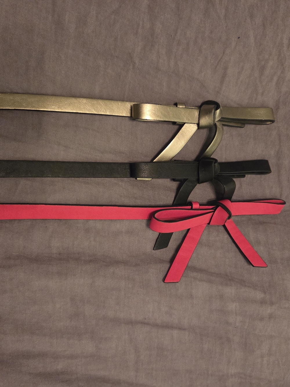 The Limited Thin Bow Tie Belts in Gold, Black, and Red